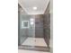 Walk-in shower featuring grey tiling, glass doors, and a white tiled floor at 965 Boulevard Se # A, Atlanta, GA 30312