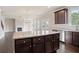 Modern kitchen with a large granite island, dark wood cabinetry, and stainless steel appliances at 3877 Lockaby Way, Lawrenceville, GA 30044