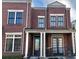 Charming brick townhouse featuring black-framed windows and a welcoming front porch with columns at 4666 Magnolia Commons, Dunwoody, GA 30338
