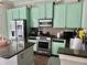 Kitchen boasts modern stainless-steel appliances, granite countertops, and mint-green cabinets at 4666 Magnolia Commons, Dunwoody, GA 30338