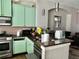 Kitchen featuring a stainless-steel range, granite countertops, and mint-green cabinets at 4666 Magnolia Commons, Dunwoody, GA 30338