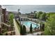 Community pool area with lounge chairs, umbrellas, and manicured landscaping surrounded by brick townhomes at 4666 Magnolia Commons, Dunwoody, GA 30338