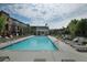 Community pool with lounge seating surrounded by trees and townhomes under a sunny, cloudy sky at 4666 Magnolia Commons, Dunwoody, GA 30338