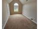 Bedroom with neutral walls, carpet, and large arched window at 7214 Bedrock Cir, Lithonia, GA 30038