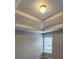 Bedroom features neutral walls, tray ceiling and large window at 7214 Bedrock Cir, Lithonia, GA 30038