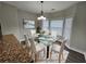 Bright dining room features modern chandelier and glass table with seating for six at 7214 Bedrock Cir, Lithonia, GA 30038