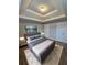 Main bedroom features a tray ceiling, bedside tables and a king bed with a TV at 7214 Bedrock Cir, Lithonia, GA 30038