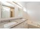 Bright bathroom featuring double sinks, granite countertop, soaking tub, and modern fixtures at 2750 Dominion Walk Ln, Snellville, GA 30078