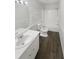 Bathroom with a light wood-look floor, white walls, shower/tub combo, sink, toilet, and mirror at 3764 Cherokee Overlook Dr, Canton, GA 30115