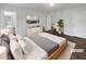 Staged bedroom with a large bed, modern dresser, and a view of the en-suite bathroom at 3764 Cherokee Overlook Dr, Canton, GA 30115