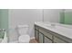 This bathroom features a toilet, vanity, and shower with classic green tiling at 395 Pharr Ne Rd # 301, Atlanta, GA 30305