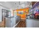 Entertaining bar area featuring stainless appliances, custom cabinets, shelving, orange accent wall, and hardwood flooring at 4115 Merritt Dr, Cumming, GA 30041