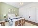 Bright bedroom with a green accent wall, hardwood floors, and a stylish, modern chandelier light fixture at 4115 Merritt Dr, Cumming, GA 30041