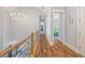 A well lit, spacious hallway on the second floor with modern wood floors, railing, and modern lighting at 4115 Merritt Dr, Cumming, GA 30041