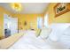 Bright bedroom with yellow walls, white bedding, and stylish chandelier at 4115 Merritt Dr, Cumming, GA 30041