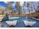 Relaxing in-ground pool with integrated spa and tanning ledge surrounded by mature trees at 4115 Merritt Dr, Cumming, GA 30041