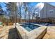 Enjoy the in-ground pool with integrated spa surrounded by stone patio and wooded scenery at 4115 Merritt Dr, Cumming, GA 30041