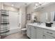 Bright bathroom featuring a shower-over-tub, a vanity with white cabinets, and a large mirror at 10 Clarke Hill St, Decatur, GA 30030