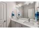 Bathroom with double sinks, a large mirror, white cabinets, and neutral colored walls at 10 Clarke Hill St, Decatur, GA 30030