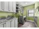 Well-organized laundry room with granite counters, white cabinets, a sink, and a modern washer and dryer at 10 Clarke Hill St, Decatur, GA 30030