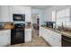 Well-lit kitchen featuring granite countertops and modern black appliances at 3214 Country Walk Dr, Powder Springs, GA 30127