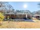 Back view of home with a brick exterior, sunny backyard and mature trees at 1722 Detroit Nw Ave, Atlanta, GA 30314