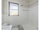 Bright bathroom featuring white tiled walls, a bathtub, and a window providing natural light at 1722 Detroit Nw Ave, Atlanta, GA 30314