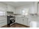 Modern kitchen with stainless steel appliances, white cabinets, and countertops at 1722 Detroit Nw Ave, Atlanta, GA 30314