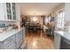 Open kitchen concept with a dining area, white cabinets, hardwood floors, and ample counter space at 42 Windrush Dr, White, GA 30184