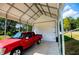 Carport with an overhead door to the shop and vehicle parked in the concrete pad at 1291 Pleasant Grove Church Rd, Villa Rica, GA 30180
