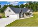 Side view of a single-Gathering home featuring a two-car garage and manicured front lawn at 1291 Pleasant Grove Church Rd, Villa Rica, GA 30180