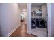 Long view of modern laundry room with washer, dryer, shelving, wood floors, and bright interior lighting at 1291 Pleasant Grove Church Rd, Villa Rica, GA 30180