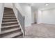 Carpeted staircase with decorative black iron railing leads to an upper level with neutral carpeting at 139 Jameson E Dr, Acworth, GA 30102