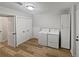 Well-lit laundry room with new washer, dryer, folding area, and storage at 332 Hickory Acres Se Dr, Smyrna, GA 30082