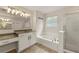 Bathroom with dual sinks, granite countertop, framed mirror, and a glass shower at 511 Winter View Way, Stockbridge, GA 30281