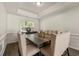 Elegant dining room featuring a large table with seating for eight, tray ceiling, and stylish decor at 511 Winter View Way, Stockbridge, GA 30281