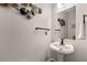 Stylish powder room with pedestal sink, modern fixtures, and decorative wall art at 511 Winter View Way, Stockbridge, GA 30281