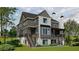 Rear exterior with covered deck, large backyard, stone accents, walkout basement, and patio at 140 Lake Estates Dr, Roswell, GA 30075