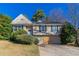 Tan home with a gabled roof, manicured shrubs, and a two-car garage at 5876 Old Wellborn Trce, Lithonia, GA 30058