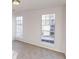This is an empty bedroom with carpeted floors, neutral walls, and natural light from the two windows at 1198 Oak Knoll Ct, Lithonia, GA 30058