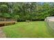 Large backyard with a well-maintained lawn, partially fenced, and backing to a tree line for added privacy at 4156 Holly Springs Rd, Rockmart, GA 30153