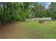 Large grassy backyard features chainlink fence, metal shed, and camper surrounded by mature trees at 4156 Holly Springs Rd, Rockmart, GA 30153