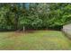 Spacious grassy backyard featuring mature trees and a chain link fence offers plenty of privacy at 4156 Holly Springs Rd, Rockmart, GA 30153