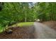 Gravel driveway leads to a property surrounded by lush greenery and mature trees, providing a serene and private entrance at 4156 Holly Springs Rd, Rockmart, GA 30153