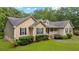 Inviting single-story home with a covered front porch, complemented by lush landscaping and mature trees at 4156 Holly Springs Rd, Rockmart, GA 30153