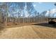 Expansive backyard featuring a well-maintained lawn, mature trees, and an outdoor patio for entertaining at 6035 Hendrix Rd, Cumming, GA 30040