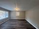 Spacious living room with dark wood-look floors, recessed lighting, and large windows at 3900 Boulder Park Sw Dr, Atlanta, GA 30331