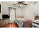 Cozy bedroom features hardwood floors, a ceiling fan, and a large window at 338 Saratoga Pl, Riverdale, GA 30296
