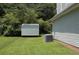 This backyard features a storage shed, air conditioning unit, lush grass, and green trees at 5627 Isleworth Ct, Atlanta, GA 30349