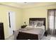 Bedroom features a dark wood bed frame with decorative pillows, curtains, and neutral colored walls at 5627 Isleworth Ct, Atlanta, GA 30349